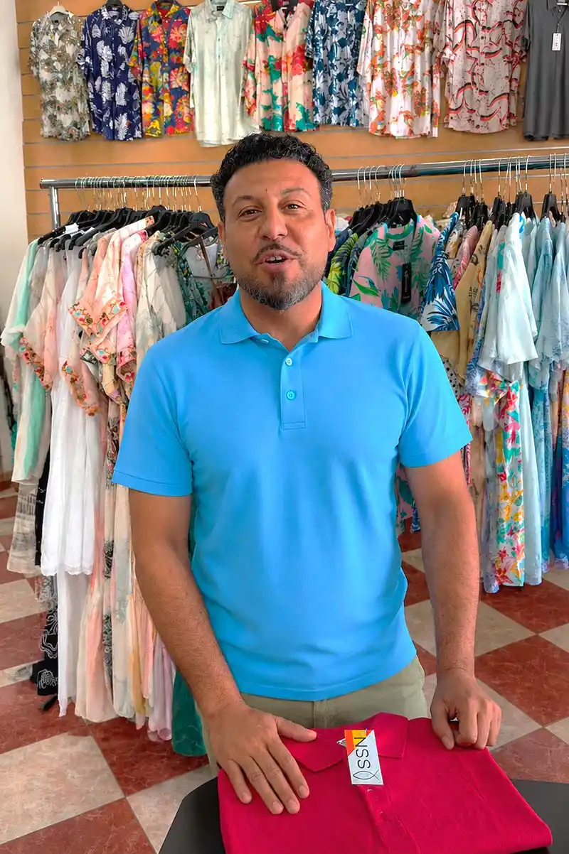 joselito que vende baratito mostrando una nueva colección de ropa en su tienda de moda